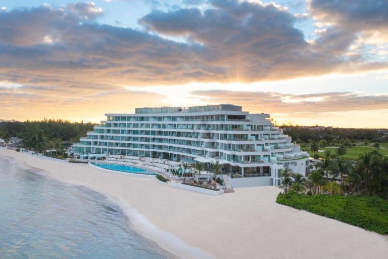 Vista aérea del Goldwynn Resort & Residences con piscina exterior y playa de arena blanca al atardecer