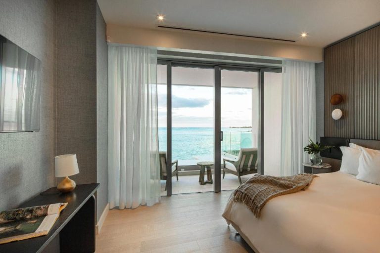 Habitación de lujo con vista al mar turquesa y balcón privado en Goldwynn Resort & Residences