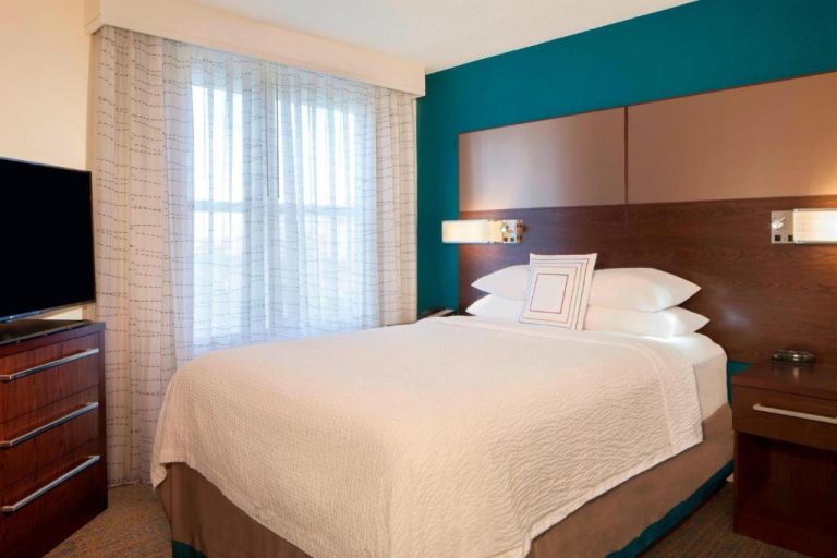 Habitación con cama king size y cabecero de madera en Residence Inn Tampa Downtown