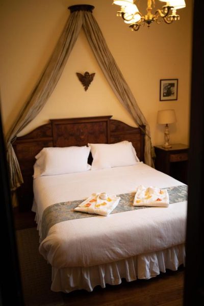 Habitación clásica con cama matrimonial y dosel elegante en Mansion Alcazar