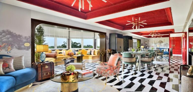 Lujoso salón de suite con techo rojo, sofás coloridos y suelo en damero del Taj Mahal New Delhi