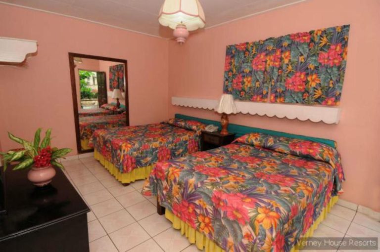 Habitación doble con camas de diseño tropical y decoración colorida en Verney House Resort