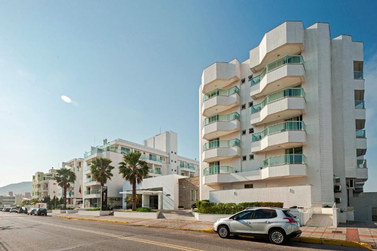 Fachada exterior del Slaviero Hotel Ingleses Convention con edificio blanco y balcones frente al mar
