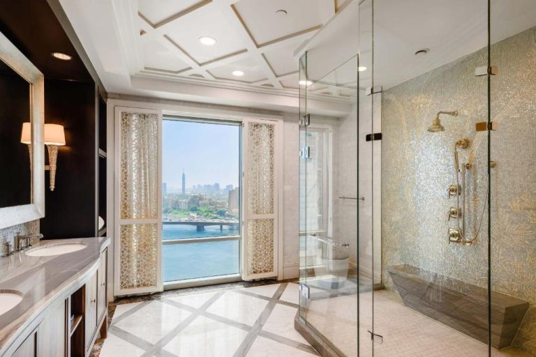 Baño de lujo con ducha de cristal y vistas al río Nilo en The St. Regis Cairo