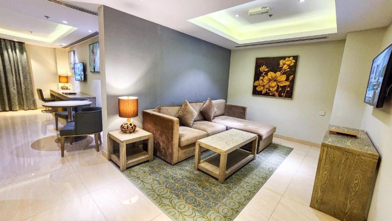 Salón elegante de suite con sofá, mesa de centro y zona de comedor en Centara Muscat Hotel Oman