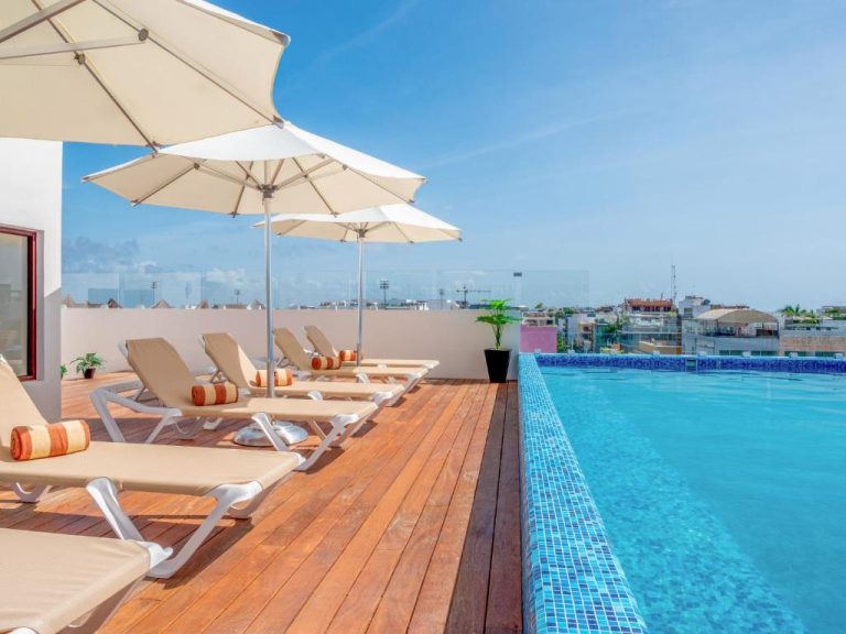 Piscina infinita con solarium y tumbonas en la terraza del hotel Lahun Suites Playa del Carmen
