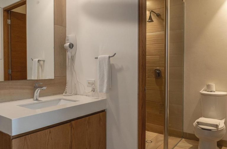 Baño moderno con ducha de lluvia y tocador en Lahun Suites Playa del Carmen