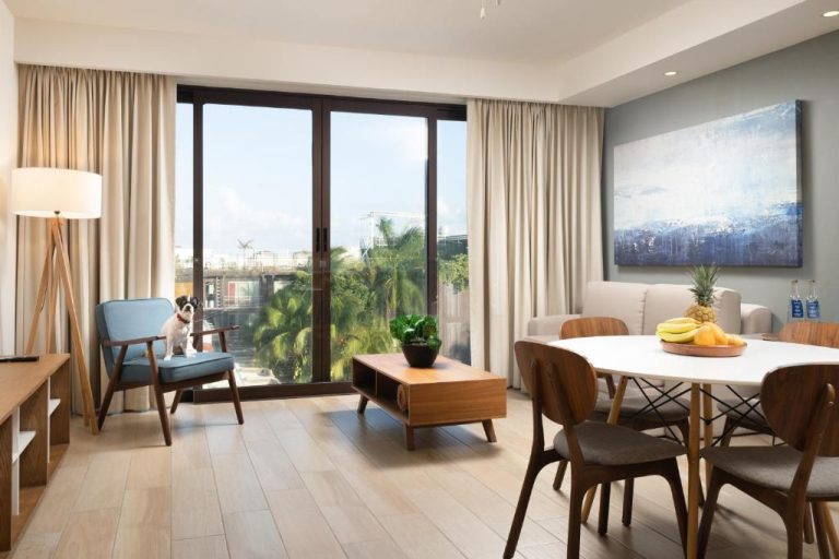 Sala de estar y comedor moderno con vista a palmeras en Lahun Suites Playa del Carmen