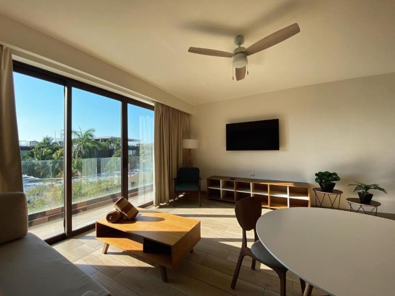 Sala de estar moderna con terraza y vistas al exterior en Lahun Suites Playa del Carmen