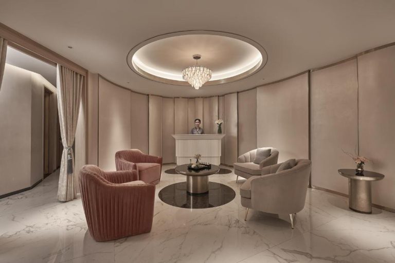 Elegante lobby con sillones de terciopelo rosa y recepción del hotel La Siesta Premium Saigon