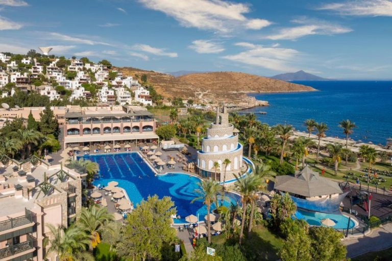 Vista aérea de la piscina exterior y zona de toboganes del Selectum Collection Bodrum con vistas al mar