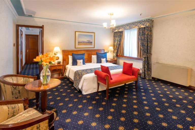 Habitación deluxe clásica con cama doble y decoración elegante en el Sarova Stanley Hotel de Nairobi