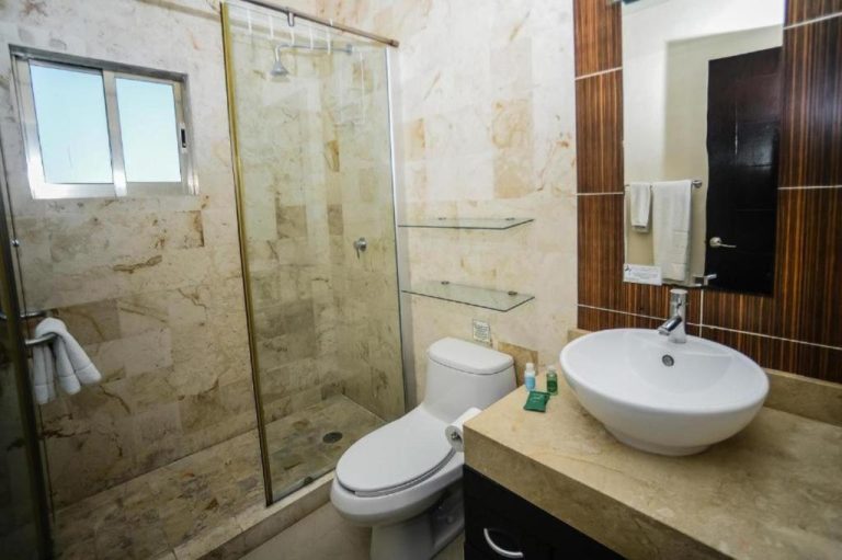 Baño moderno con ducha de mármol, lavabo de porcelana y sanitario en Hotel Encanto Riviera