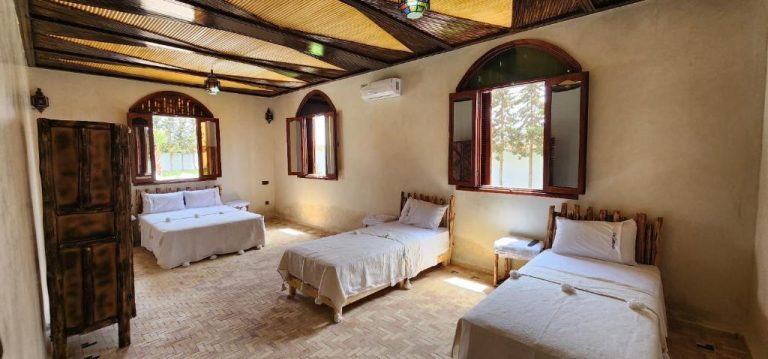 Habitación triple con camas individuales y decoración rústica tradicional en Auberge Dar Laazouzi