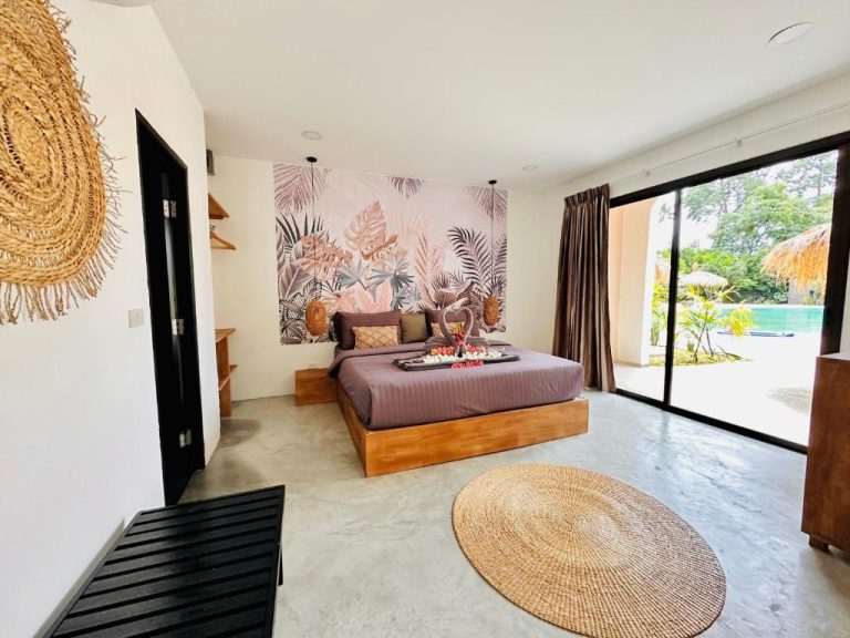 Habitación de lujo con cama doble, mural tropical y acceso directo a la piscina en Zibá Home Suites