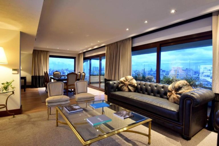 Lujoso salón de suite con sofá Chesterfield de cuero y vistas panorámicas a Buenos Aires en Marriott Downtown