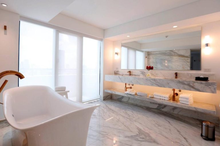 Baño de lujo con bañera exenta y doble lavabo de mármol en Marriott Buenos Aires Downtown