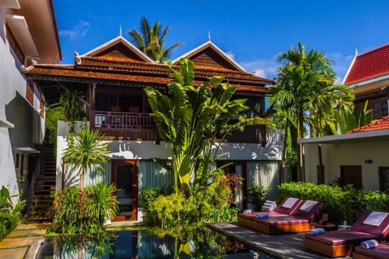 Piscina exterior con tumbonas y jardín tropical del Sokkhak Boutique Resort & Spa en Siem Reap