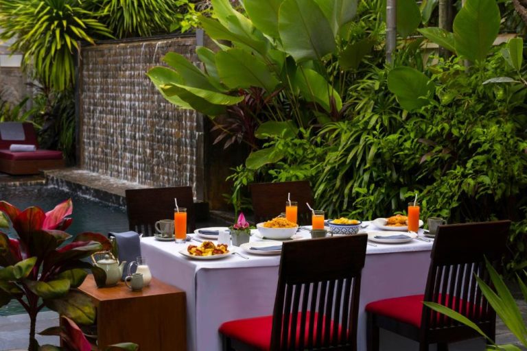 Desayuno al aire libre junto a cascada y jardín tropical en Sokkhak Boutique Resort & Spa