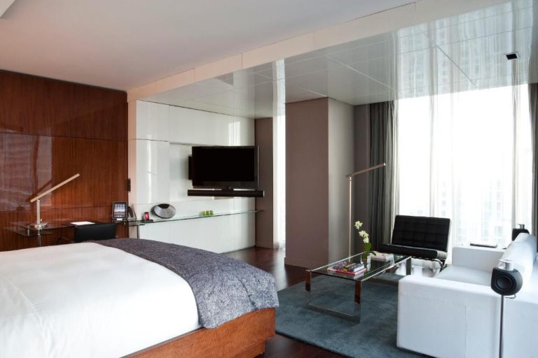 Suite de lujo con cama king y sala de estar moderna en Hotel Beaux Arts Autograph Collection