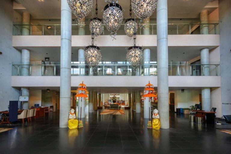 Lobby del Hilton Garden Inn Bali Ngurah Rai Airport con estatuas balinesas y lámparas decorativas