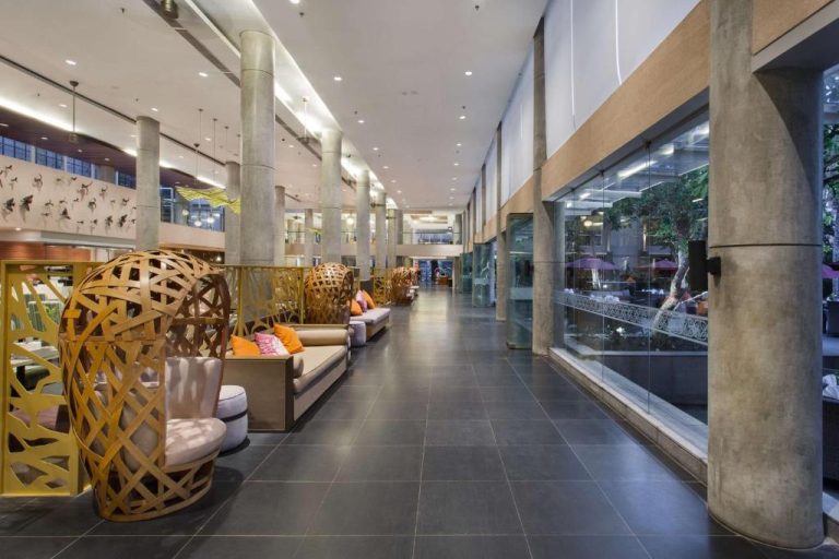 Elegante lobby lounge del Hilton Garden Inn Bali Ngurah Rai Airport con sillones decorativos y zona de descanso