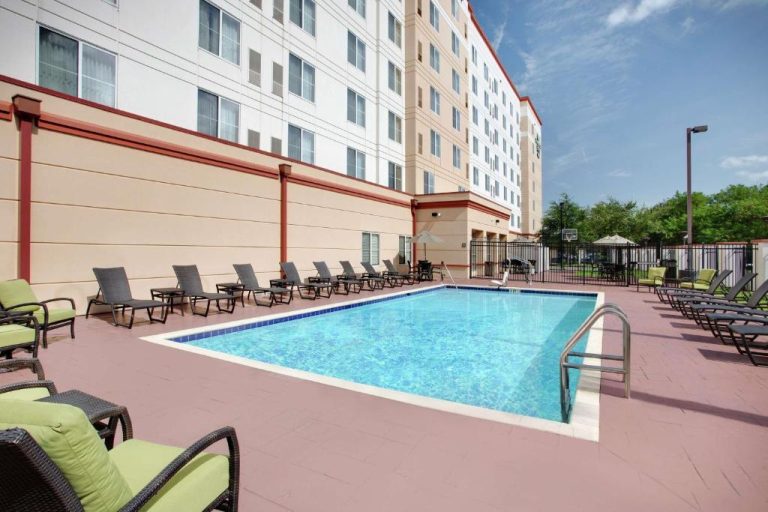 Piscina exterior con tumbonas y terraza del Homewood Suites by Hilton Tampa-Brandon