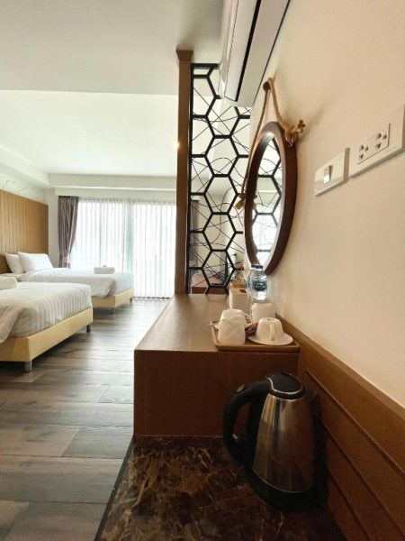 Habitación doble con escritorio, hervidor eléctrico y espejo decorativo en Baannalin Hometel Tailandia