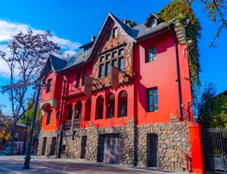 Fachada exterior roja con base de piedra del Hotel Boutique Castillo Rojo en Santiago de Chile