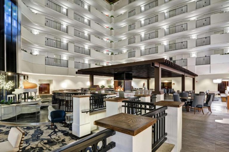Amplio atrio interior con bar central y balcones iluminados del Embassy Suites by Hilton Orlando Downtown