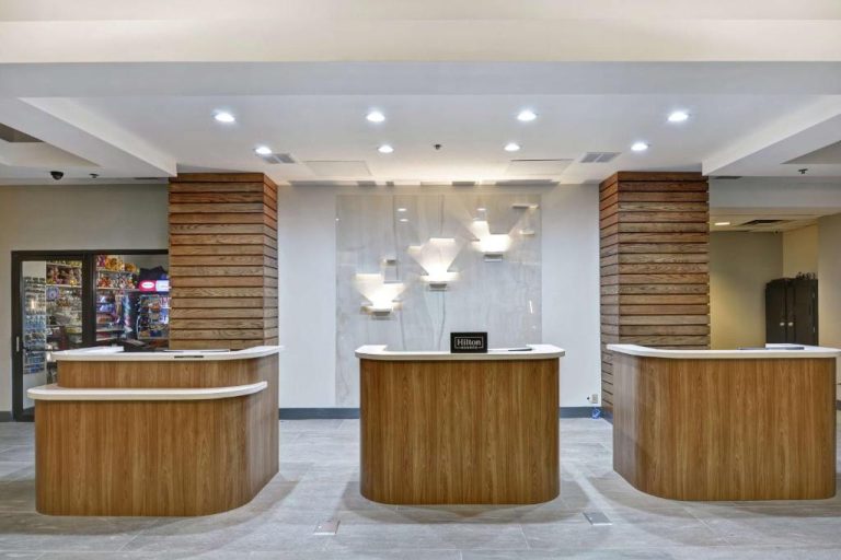 Recepción principal del Embassy Suites by Hilton Orlando Downtown con mostradores de madera y decoración moderna