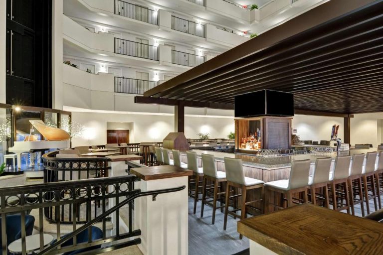 Bar y zona de copas en el atrio interior del Embassy Suites by Hilton Orlando Downtown con múltiples niveles