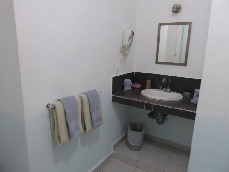 Baño con lavabo empotrado, espejo y secador de pared en el Hotel Claro de Luna