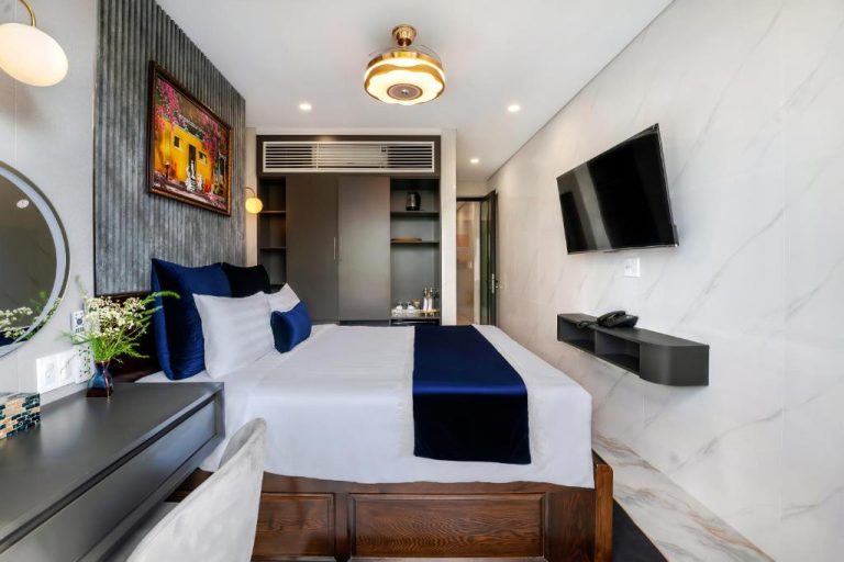 Habitación doble de lujo con cama king y decoración en azul marino en Hannah House Hoi An