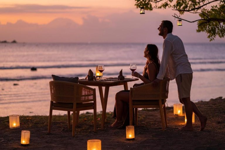 Cena romántica en la playa al atardecer con velas y copa de vino en Bleu Mathis Gili Asahan
