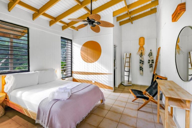 Habitación doble con techo de vigas doradas y decoración tropical en Casa Grande Mountain Retreat Adults Only