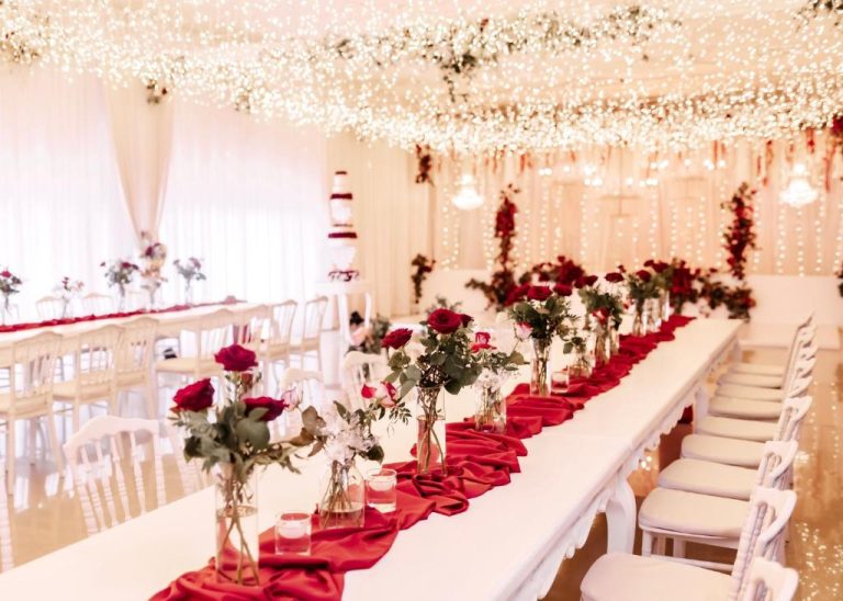Salón de eventos elegante con mesas decoradas con rosas rojas y luces en Manhattan Business Hotel Male