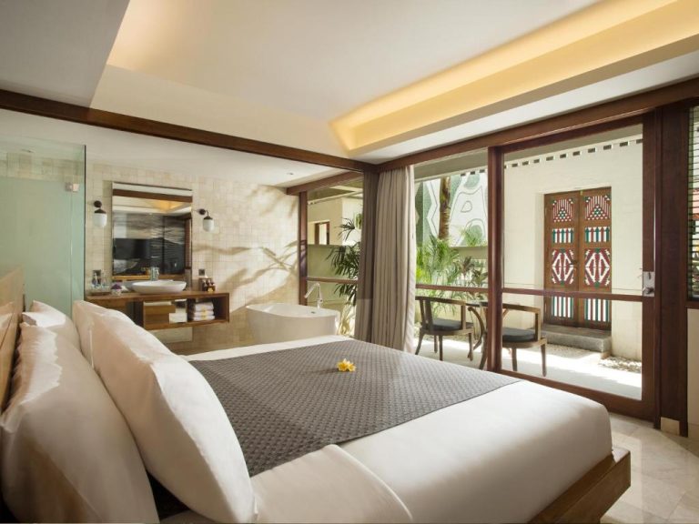 Habitación de lujo con baño abierto y terraza privada en el Amnaya Resort Kuta, Bali