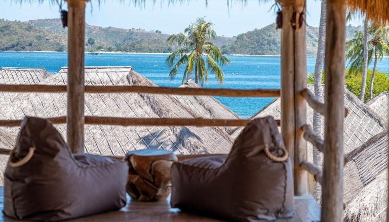 Terraza con puf y vistas al mar turquesa y palmeras en Bleu Mathis Gili Asahan