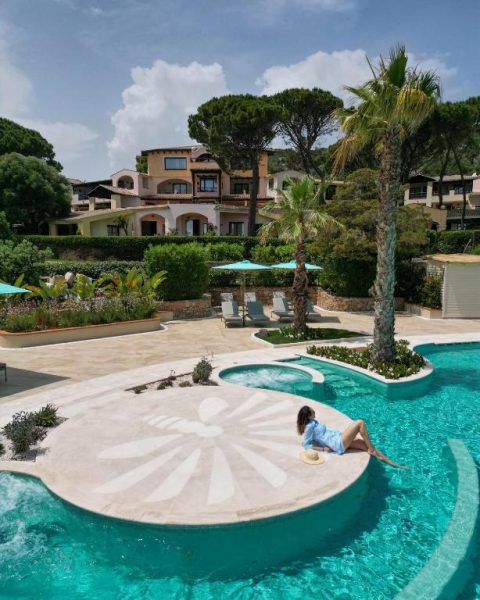 Piscina exterior de diseño con isla central del Abi d'Oru Sardinian Beach Resort & Spa en Cerdeña