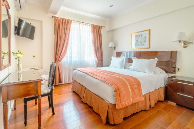 Habitación doble con cama matrimonial y suelo de madera en Orly Suites