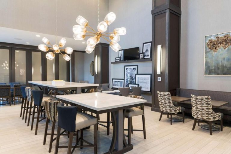 Amplio comedor moderno con mesas altas y lámparas decorativas en Hampton Inn & Suites Indianapolis-Keystone