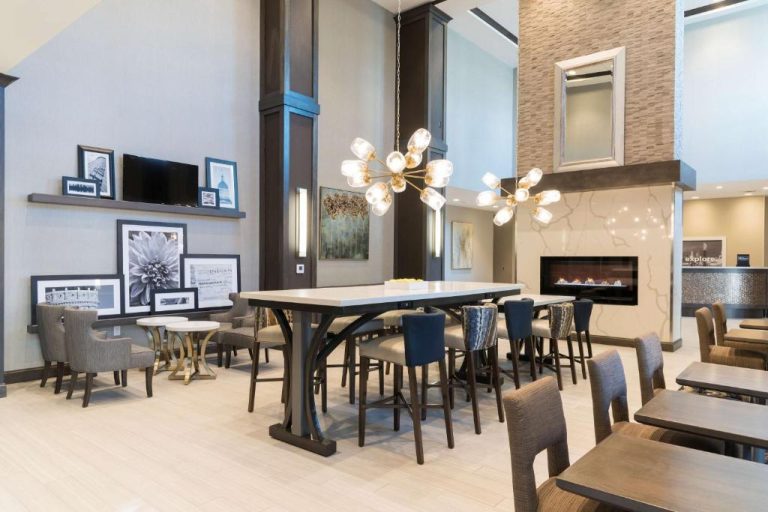 Lobby comedor con chimenea y lámparas modernas del Hampton Inn & Suites Indianapolis-Keystone