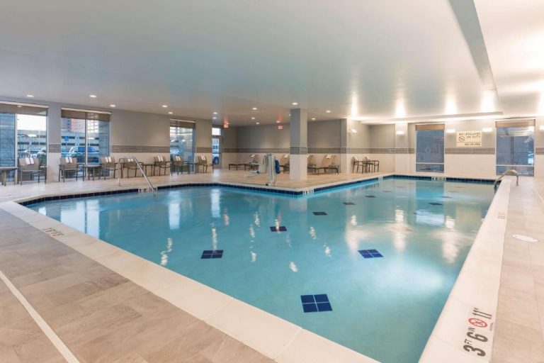 Piscina interior climatizada del Hampton Inn & Suites Indianapolis Keystone con tumbonas y acceso adaptado
