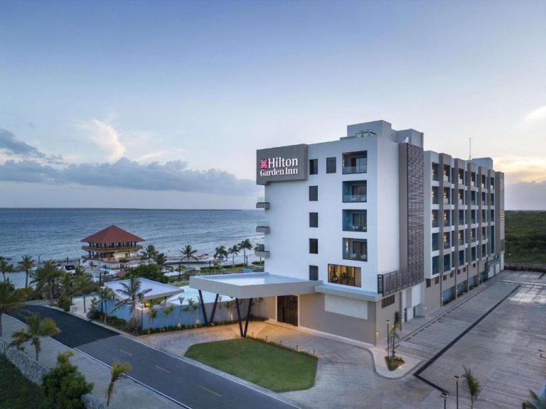 Vista aérea del Hilton Garden Inn La Romana con fachada exterior y acceso directo a la playa del Caribe