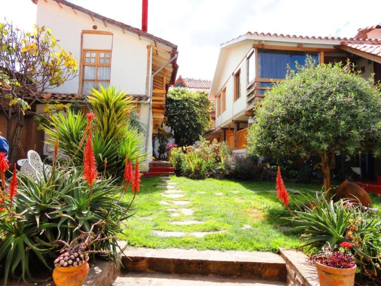 Jardín interior con sendero de piedra y plantas tropicales en la Casona La Recoleta