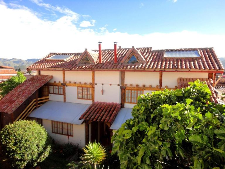 Fachada exterior de Casona La Recoleta con tejado de tejas rojas y jardines en Cusco, Perú