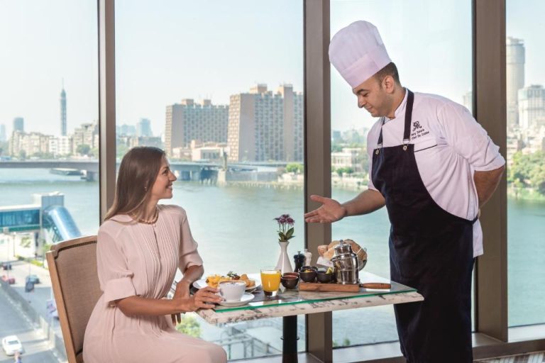 Chef presentando desayuno a huésped con vista al río Nilo en The St. Regis Cairo