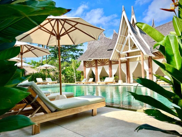 Piscina exterior con tumbonas y sombrillas del Rascals Hotel Adults Only rodeada de vegetación tropical