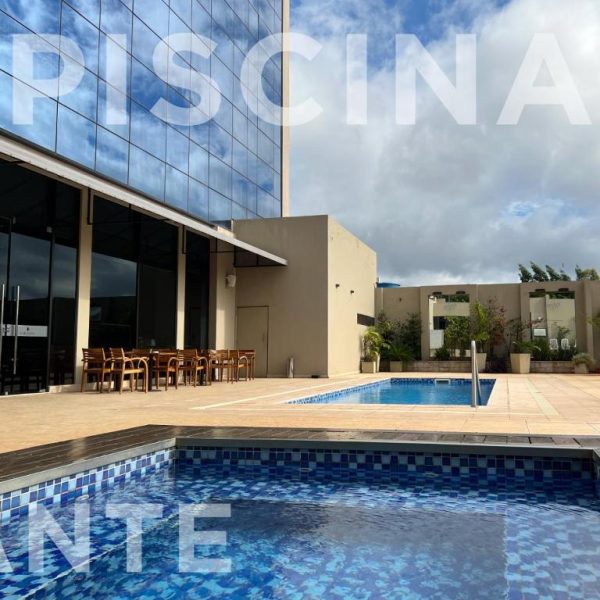 Piscina exterior con terraza y zona de descanso del Carnaval Hotel Casino junto a edificio moderno